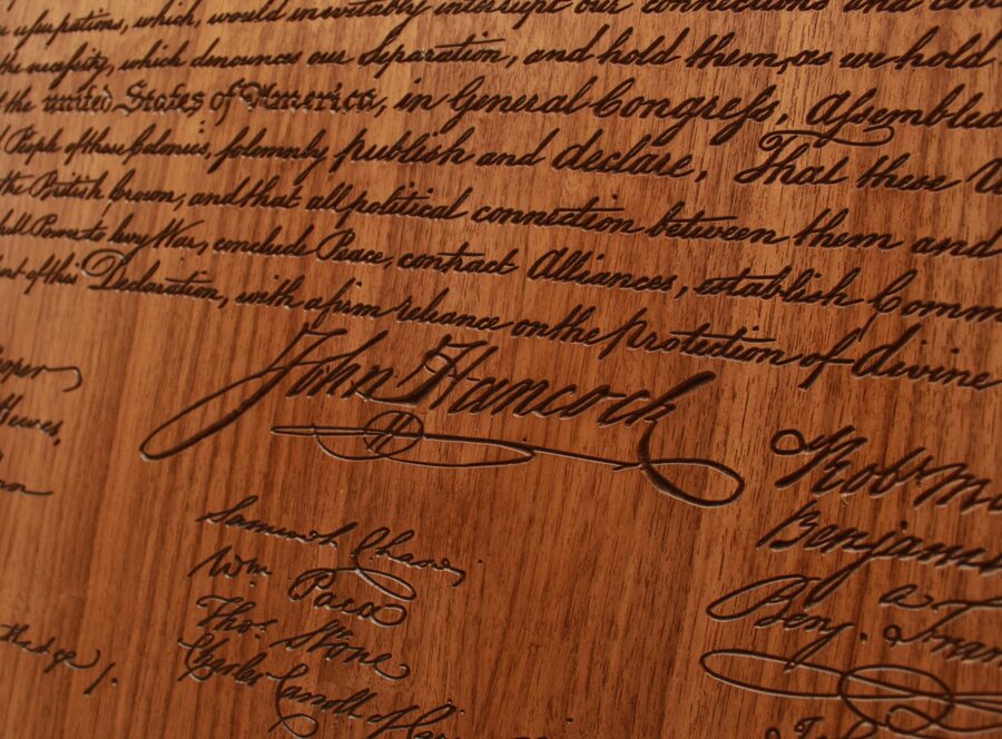 Raking light across John Hancock's carved signature in walnut